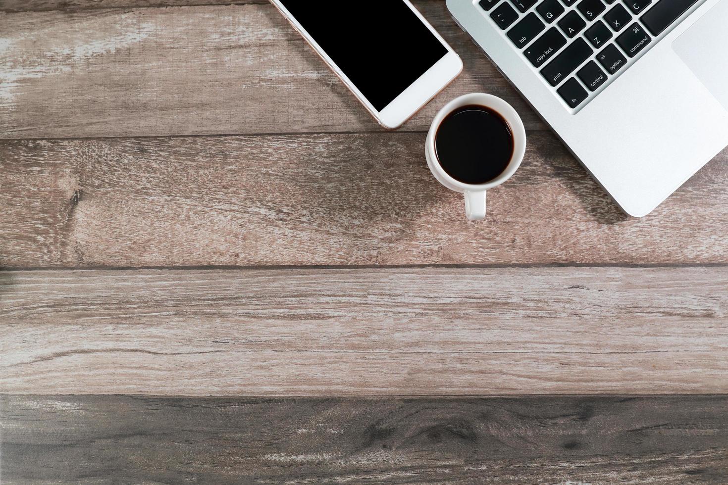 wood office desk with computer and smart phone with coffee cup photo