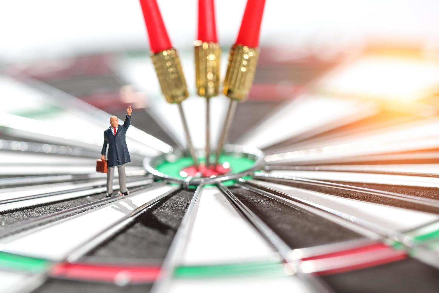 businessman standing on dartboard target center with arrows idea of financial and business goal photo