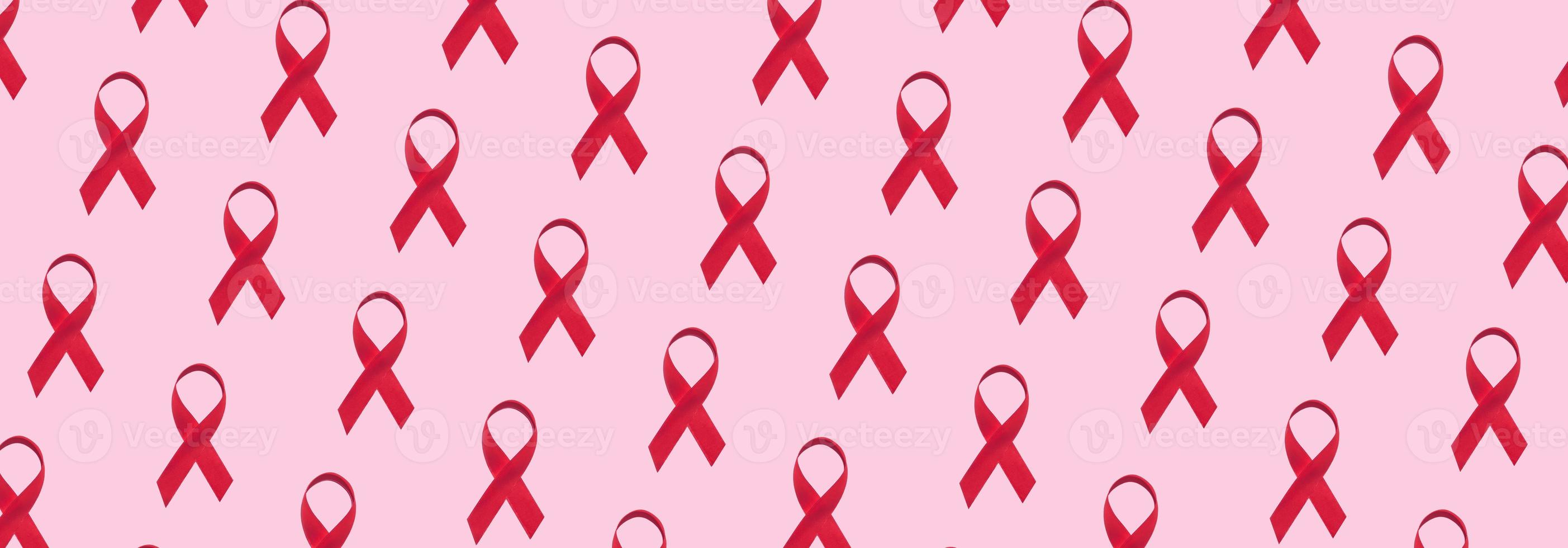 Banner with red ribbons pattern symbol of world aids day on pink background photo