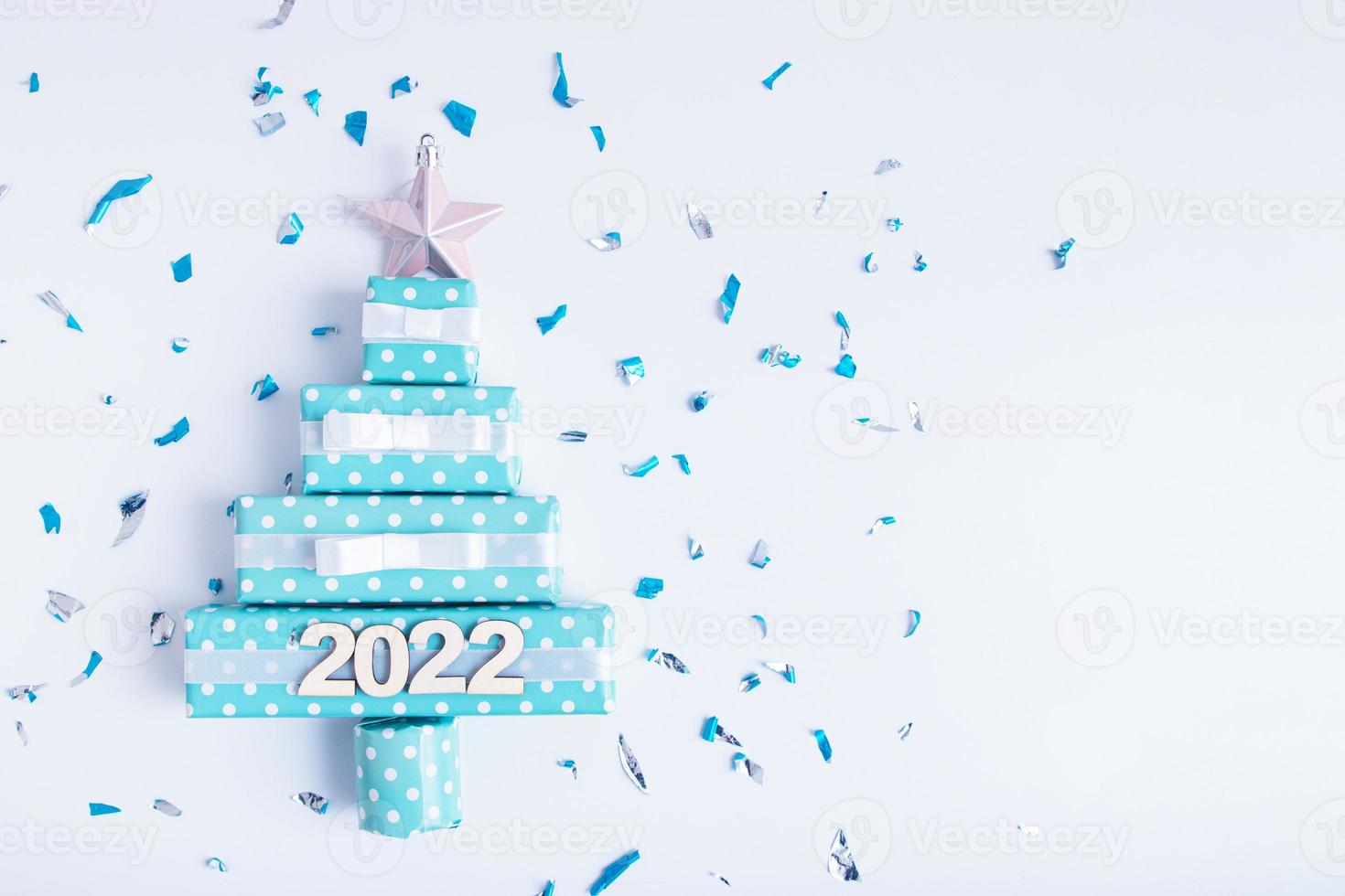 tarjeta de felicitación creativa en blanco con árbol de navidad abstracto hecho de cajas de regalo y brillos foto
