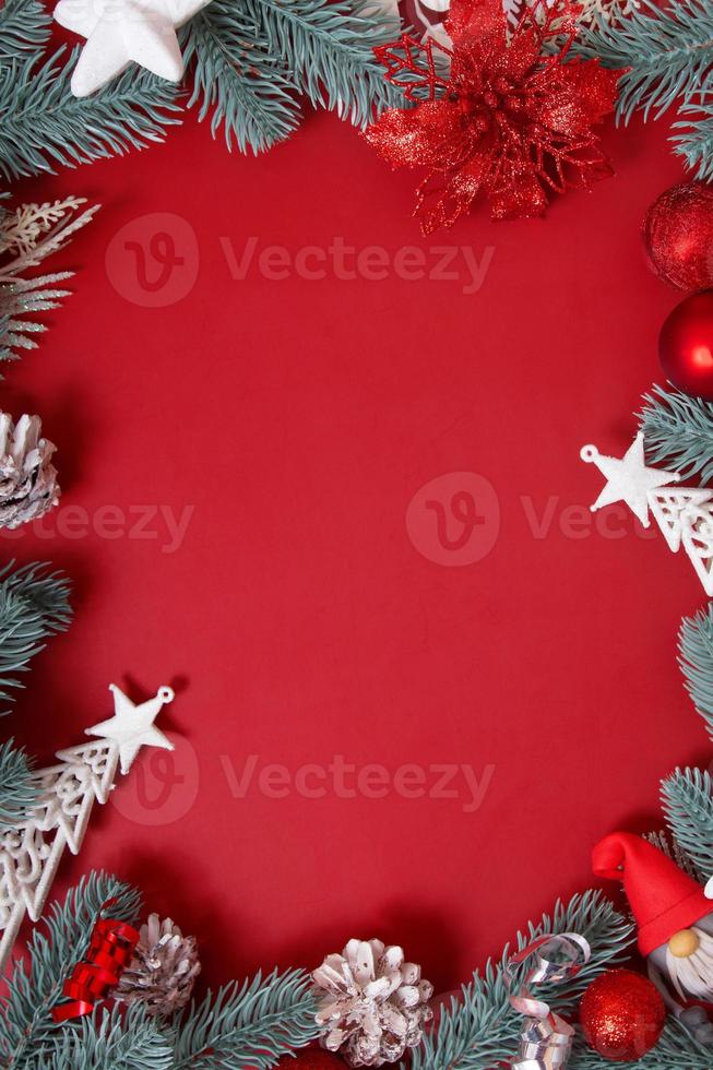 Bastidor de adornos navideños sobre fondo rojo con espacio de copia foto