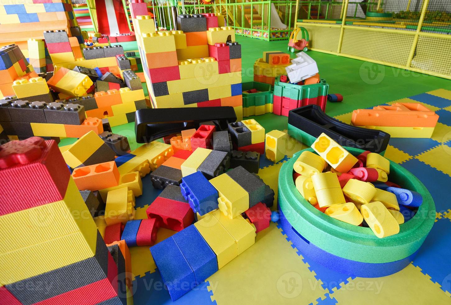 Área de juegos para niños en el interior del parque de diversiones con rompecabezas de juguete para jugar: dentro del hermoso patio de juegos para niños, juguetes de plástico de colores de la sala de juegos foto