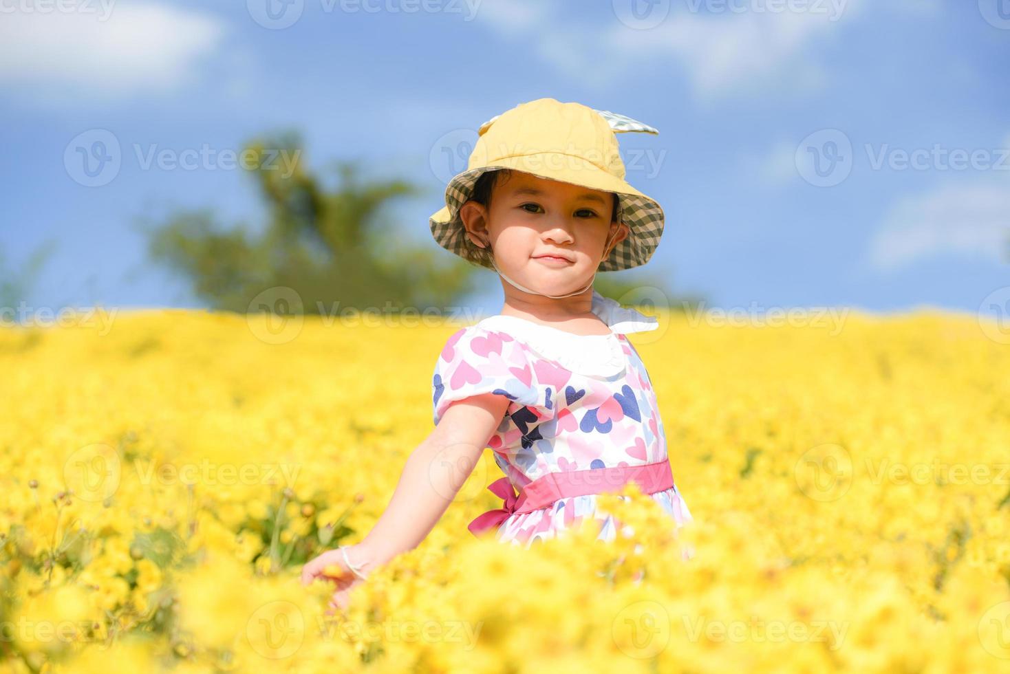 Little asian child girl have fun with a happy smiling face at the morning garden natural flower, Cute girl children kids playing outside on bright day beautiful flower in spring outdoors photo