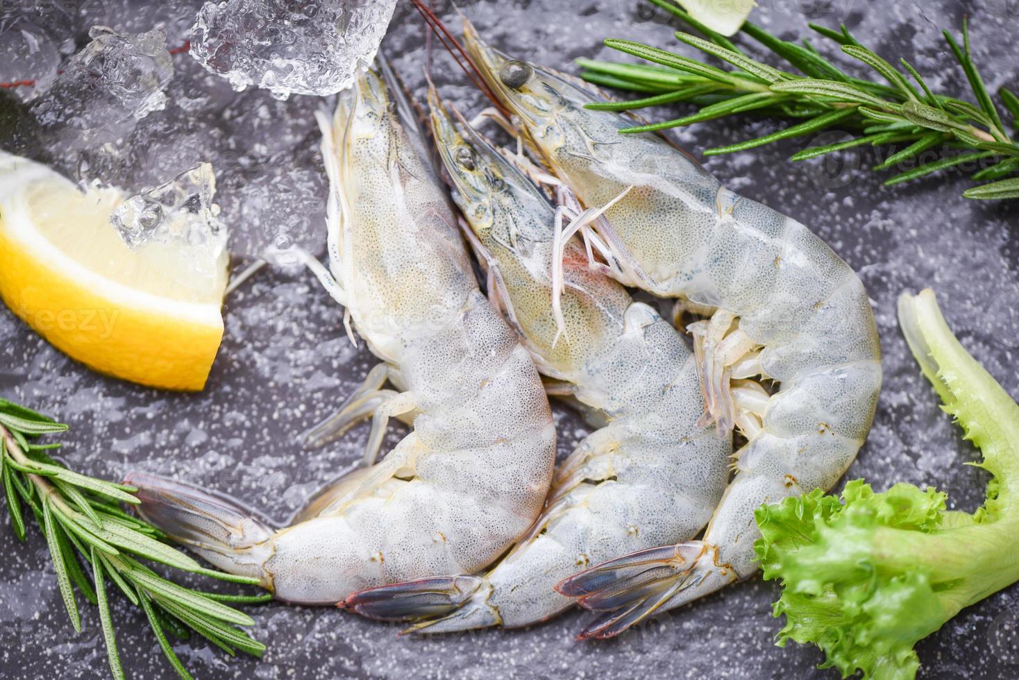 camarones crudos camarones en hielo congelados en el restaurante de mariscos - camarones frescos en una tabla de cortar de madera con ingredientes de romero hierbas y especias para cocinar mariscos foto