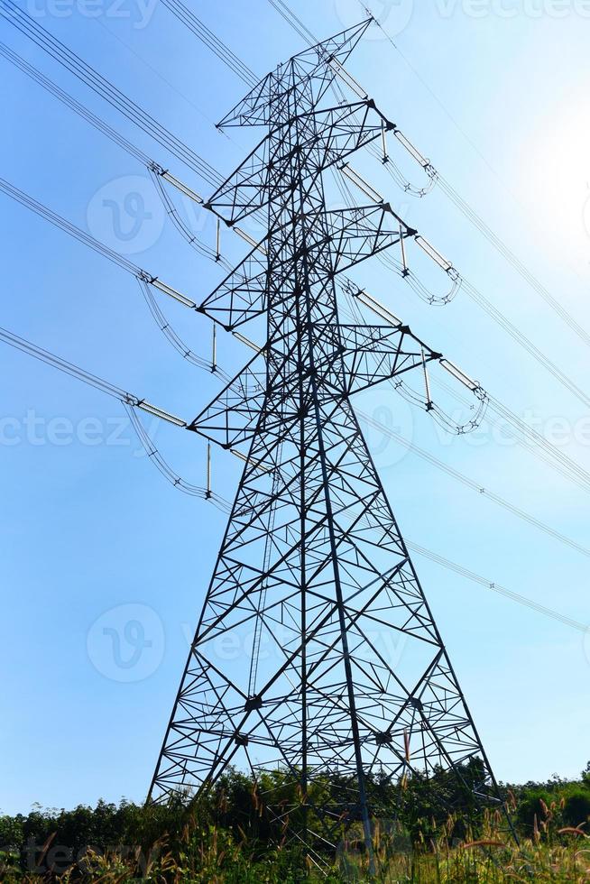 High voltage post, High voltage tower sky background on the mountain forest, Electricity poles and electric power transmission lines against countryside photo