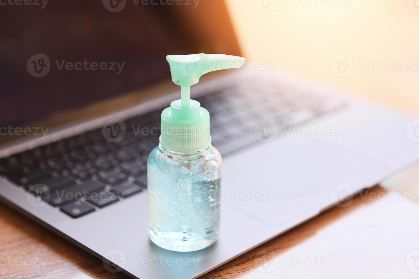 Disinfects the surface of the laptop by sanitizer spray or alcohol gel washing hand hygiene on the working place for quarantine coronavirus covid-19 working from home concept. photo