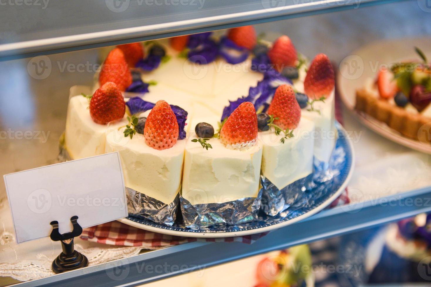 Cake on shelf with cake strawberry and blueberry on store bakery shop photo