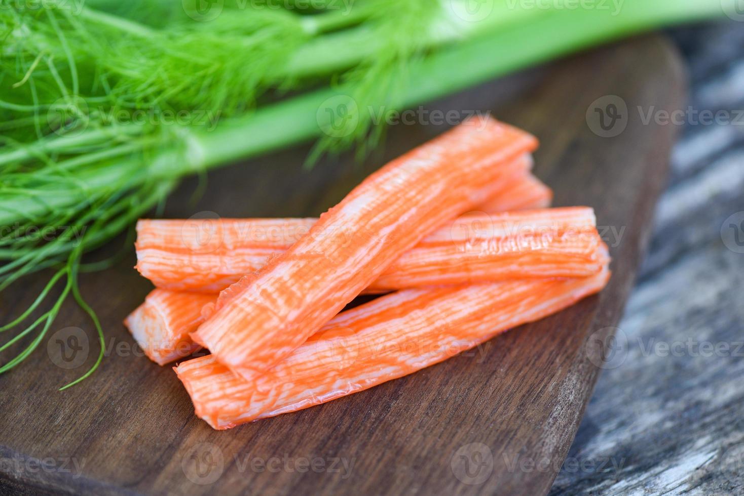 Crab sticks on wooden cutting board and vegetable , Fresh crab sticks surimi ready to eat japanese food. photo