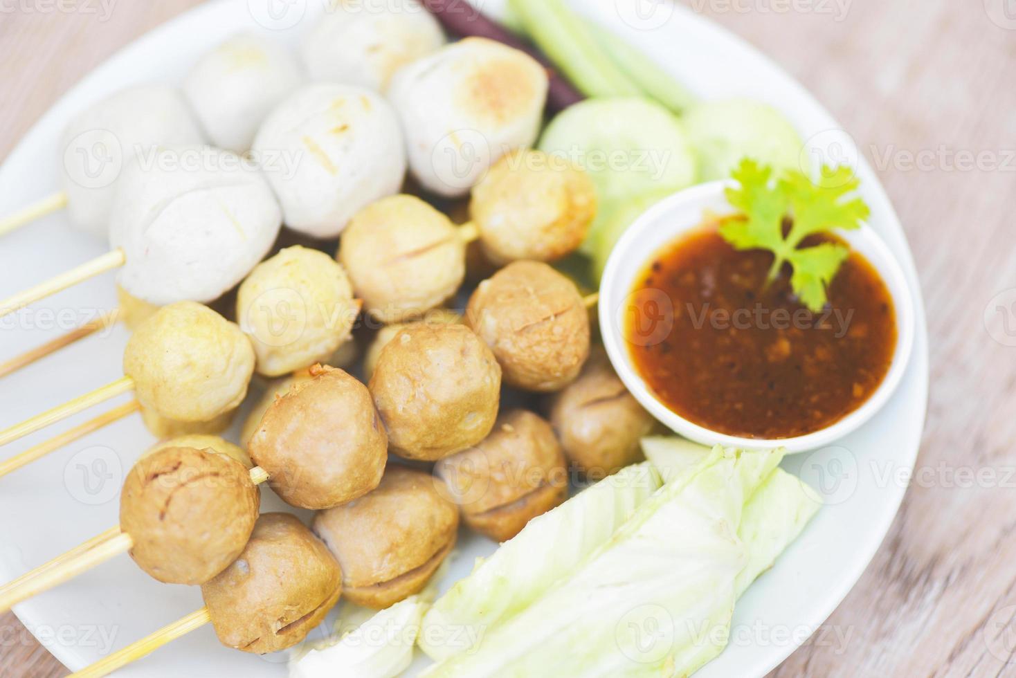 Asian Thai food grilled meatballs fishball and porkball with spicy sauce, Meatballs on skewers on white plate and fresh vegetables cabbage yard long bean cucumber photo