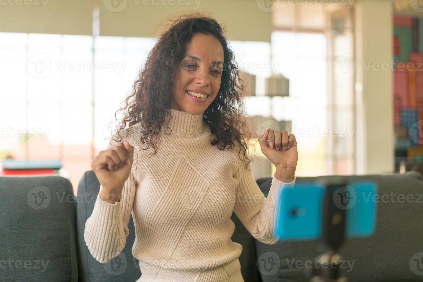 Latin woman influencer shooting video and talking with camera for blog photo