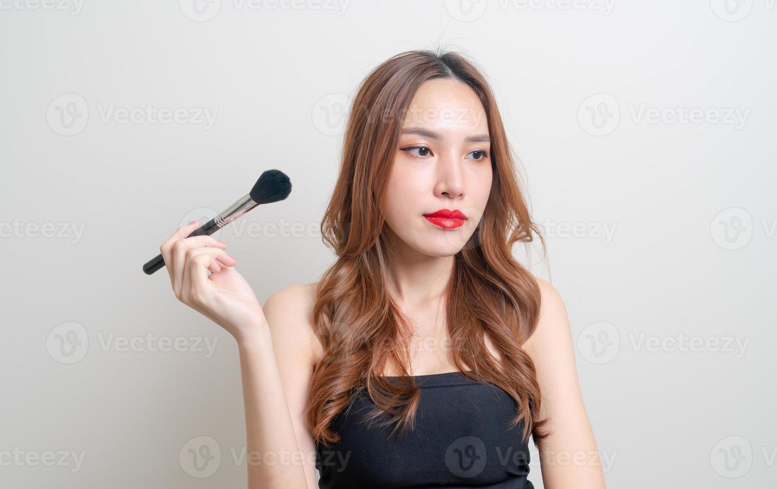 Retrato de mujer hermosa con pincel de maquillaje foto