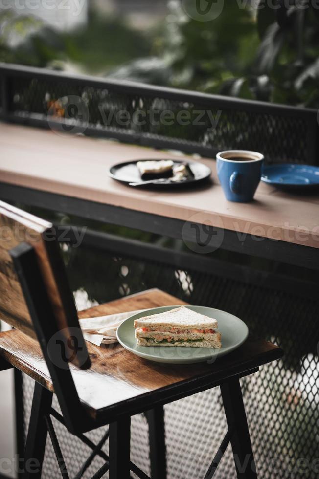 Sandwich and hot coffee on wood bar photo