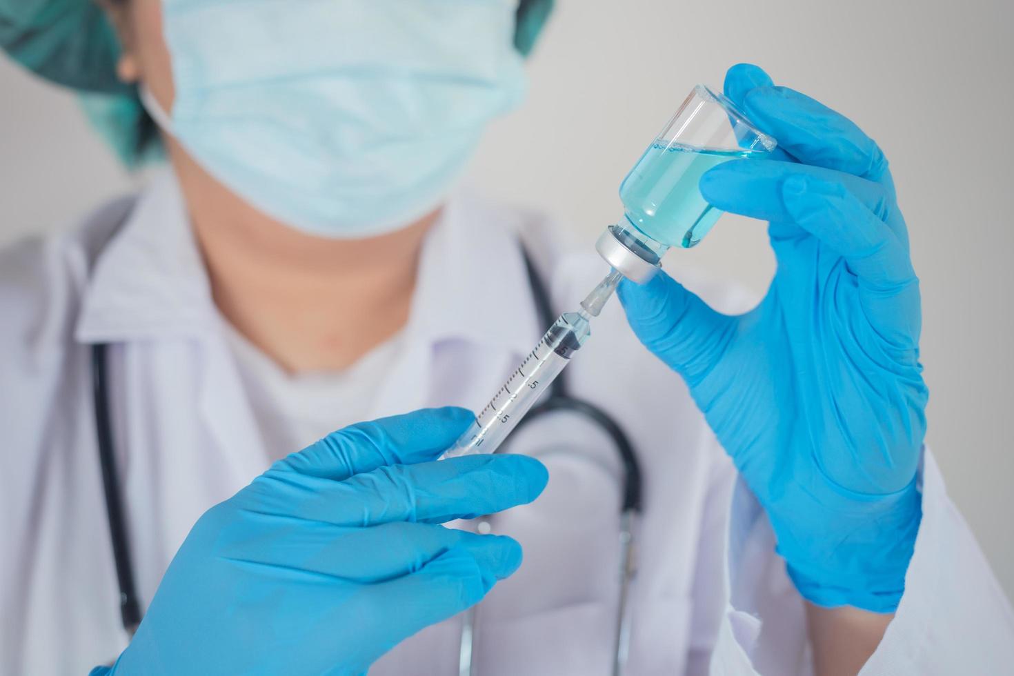 A doctor or scientist in a research laboratory holds a syringe containing a liquid vaccine. to study and analyze samples photo