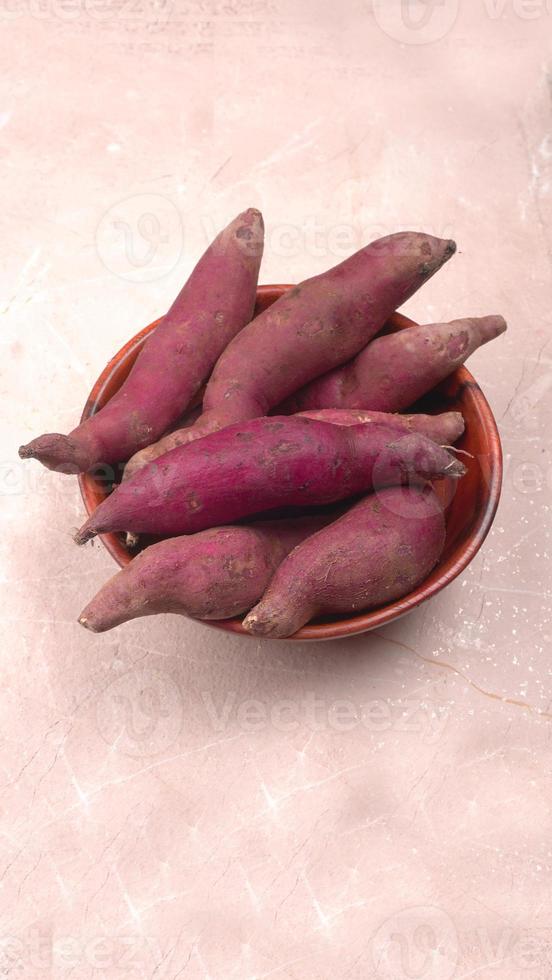 slices of sweet potatoes on wooden background, close up. Raw sweet potatoes or batatas. photo