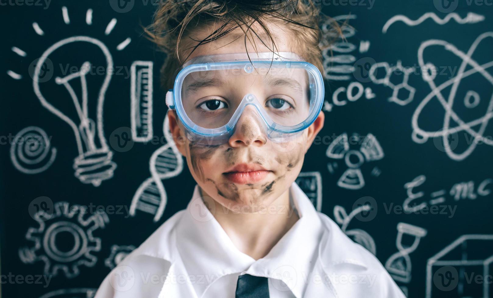 Little chemist in glasses looking seriously at camera photo