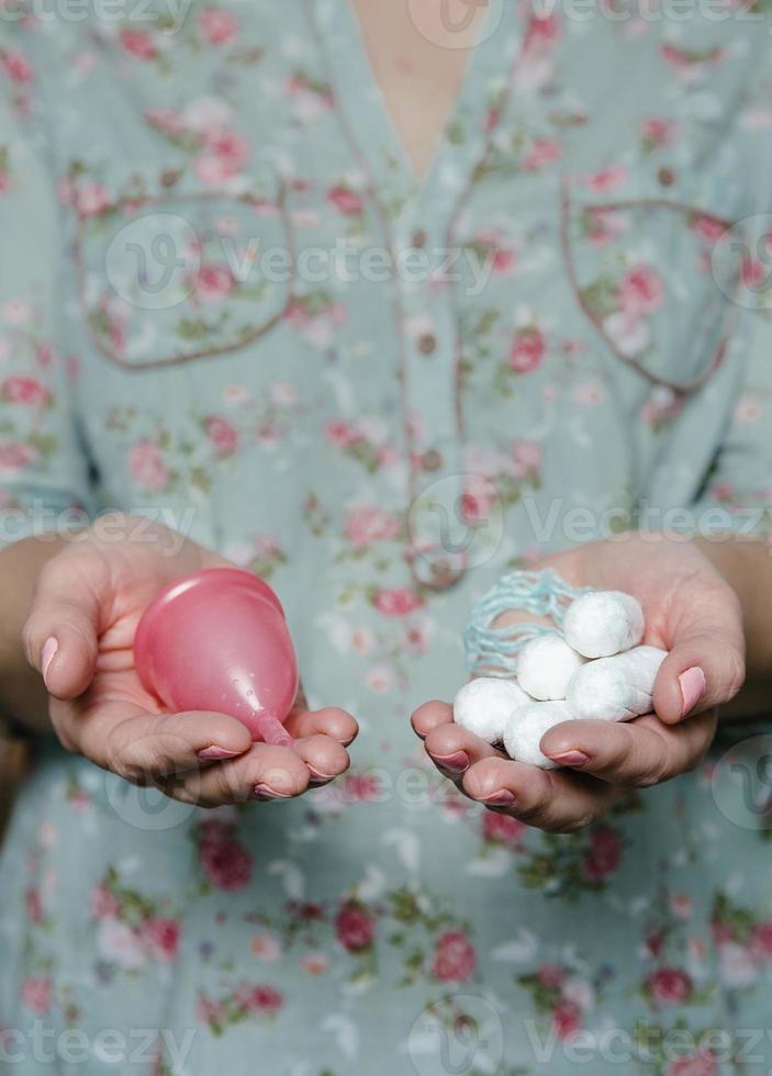 mujer sosteniendo en las manos tampones y copa menstrual foto