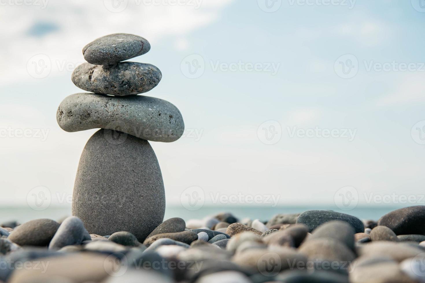 Stones pyramid on pebble beach symbolizing stability, zen, harmony, balance. Concept of freedom relaxation photo