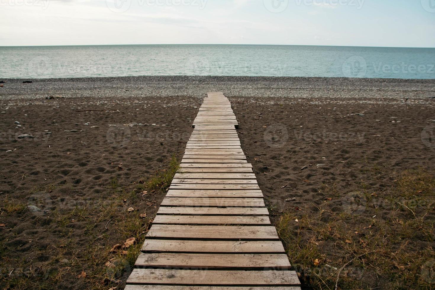 Wooden path on sandy beach photo