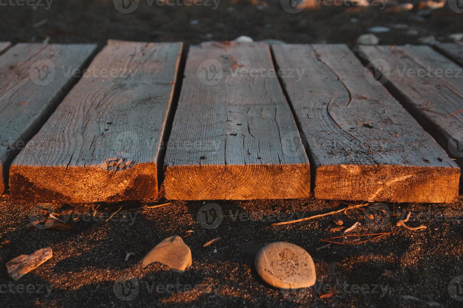 Wooden path on the sandy beach. Beach boardwalk with sand texture background photo