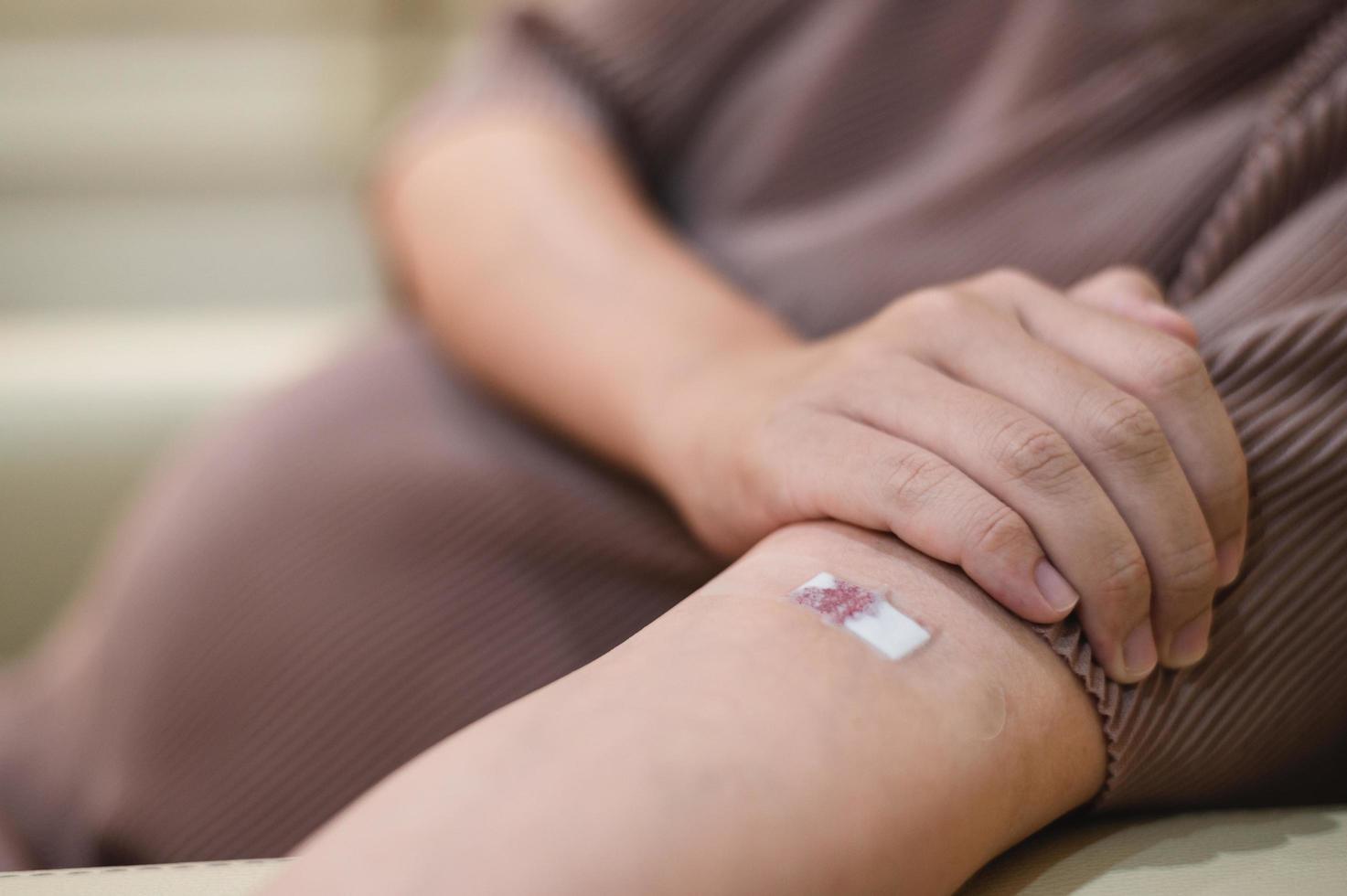 pregnant woman draws blood from an injection wound on a patient's arm. photo