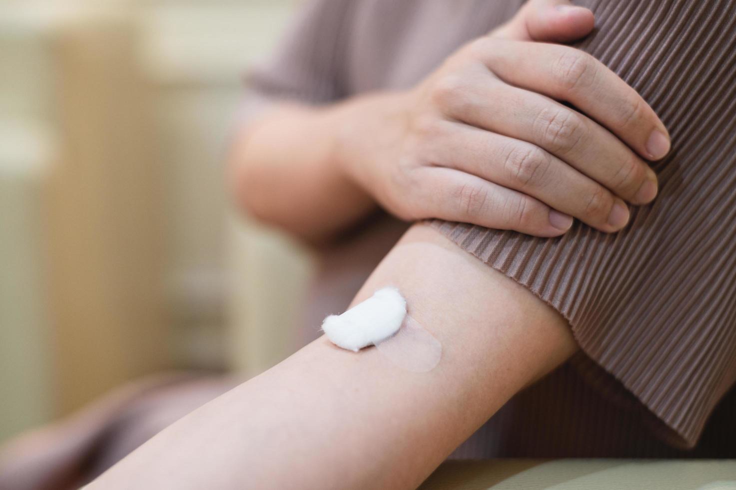 mujer embarazada extrae sangre de una herida de inyección en el brazo de un paciente. foto