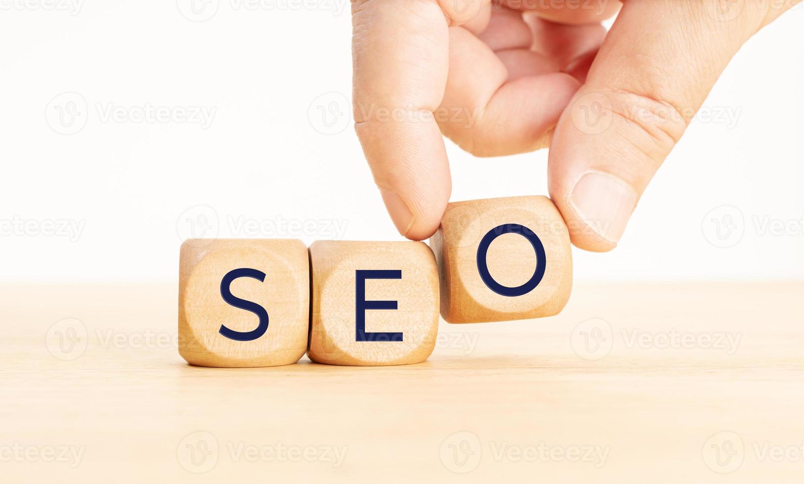 SEO or search engine optimization concept. Human hand holding a wooden block with text. Copy space photo