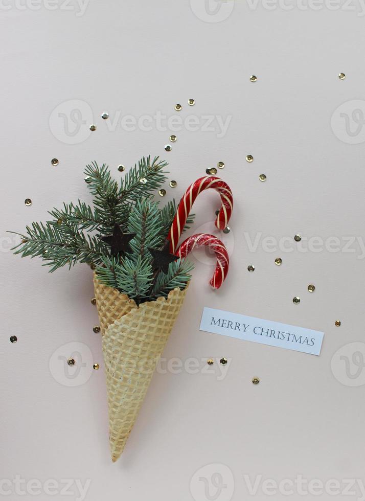 New Year Christmas holiday party celebration waffle cone candy canes fir tree branch copy space color paper background. photo