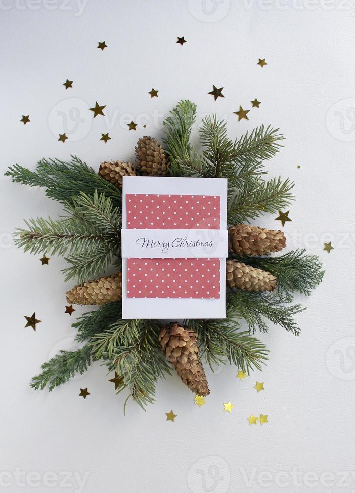Merry christmas greeting card, fir tree branches, cones and festive decor on white background, flat lay photo