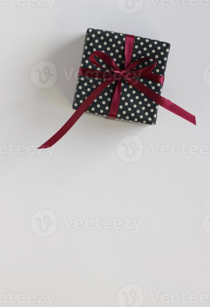 cartel de maqueta, caja de regalo con lazo blanco sobre fondo. foto