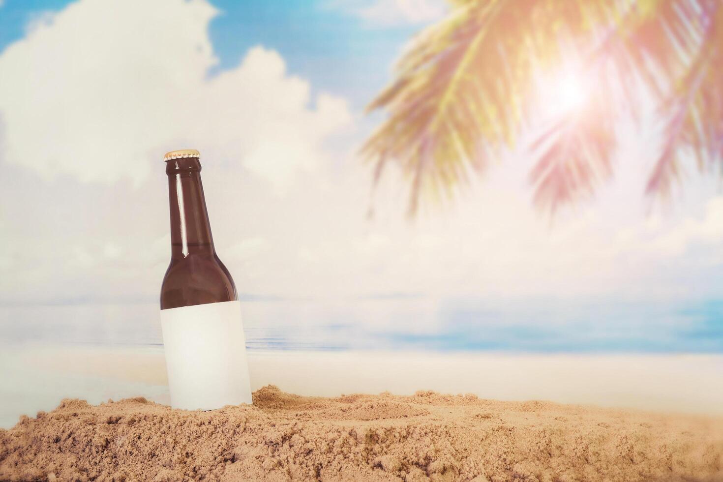 Blank Logo Beer bottle in the sand with beach background photo