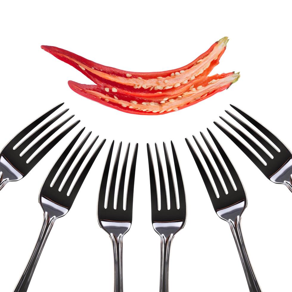 Red hot chili pepper on many fork isolated on white photo