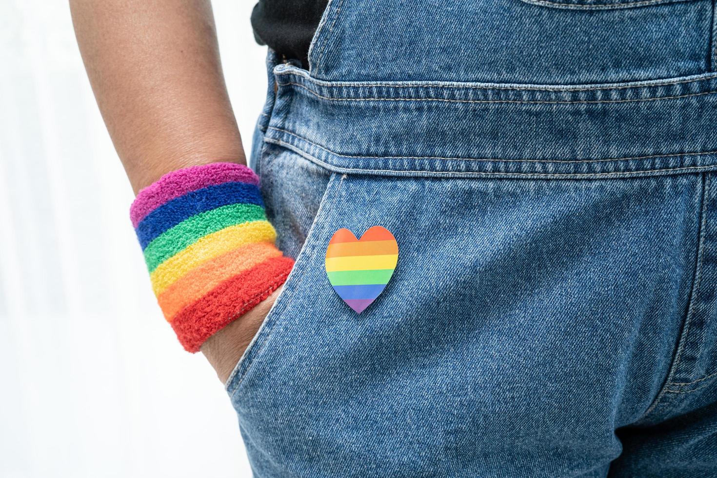 dama asiática con pulseras de la bandera del arco iris, símbolo del mes del orgullo lgbt celebran anualmente en junio las redes sociales de gays, lesbianas, bisexuales, transgénero, derechos humanos. foto