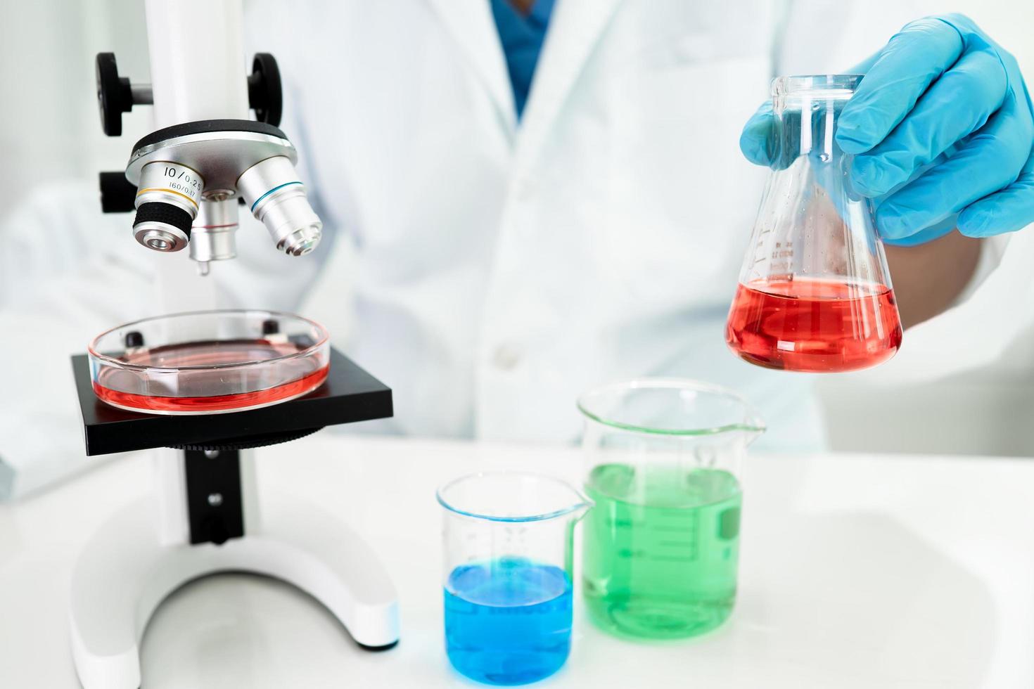 Asian scientist biochemist or microbiologist working research with a microscope in laboratory. For protect outbreak Coronavirus Covid19, bacteria and germs. photo