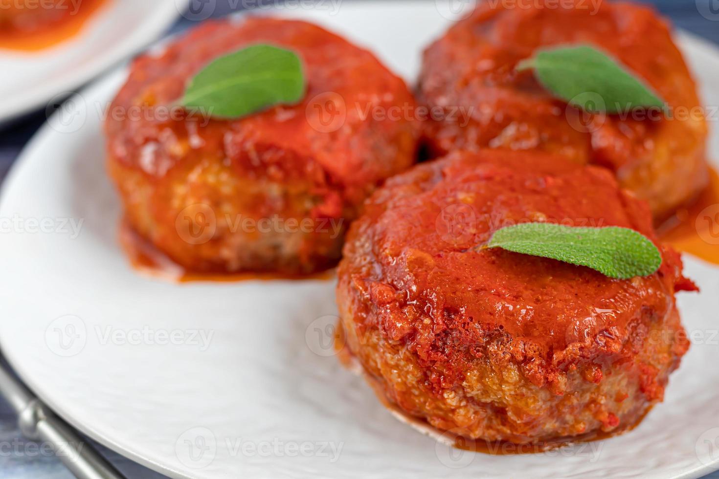 Fish cakes in tomato juice with onions and carrots. Diet. Sauerkraut. On a dark wooden background. photo