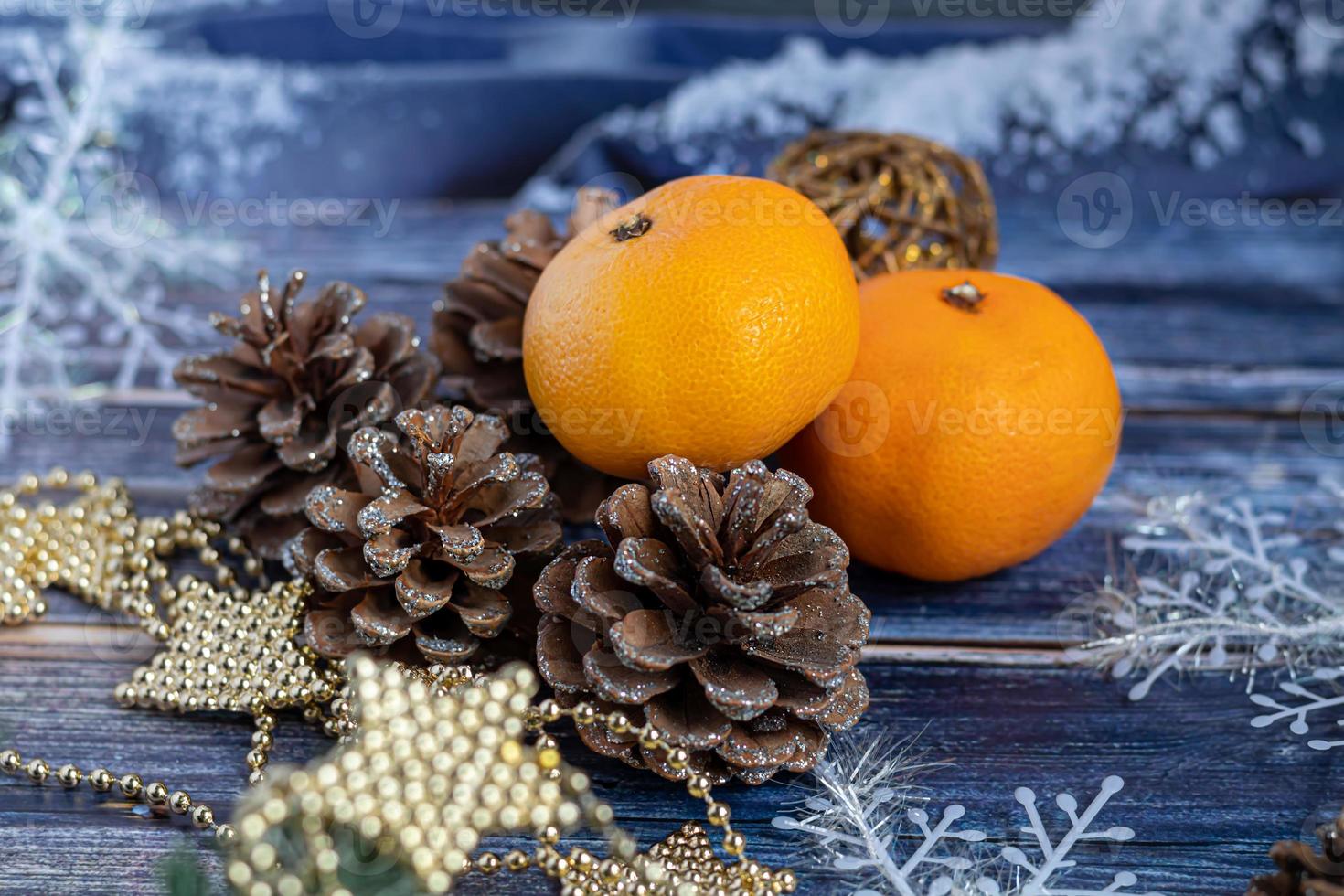 Tangerines on a gray background with branches of a Christmas tree, in the background a window with snow. New year concept. photo