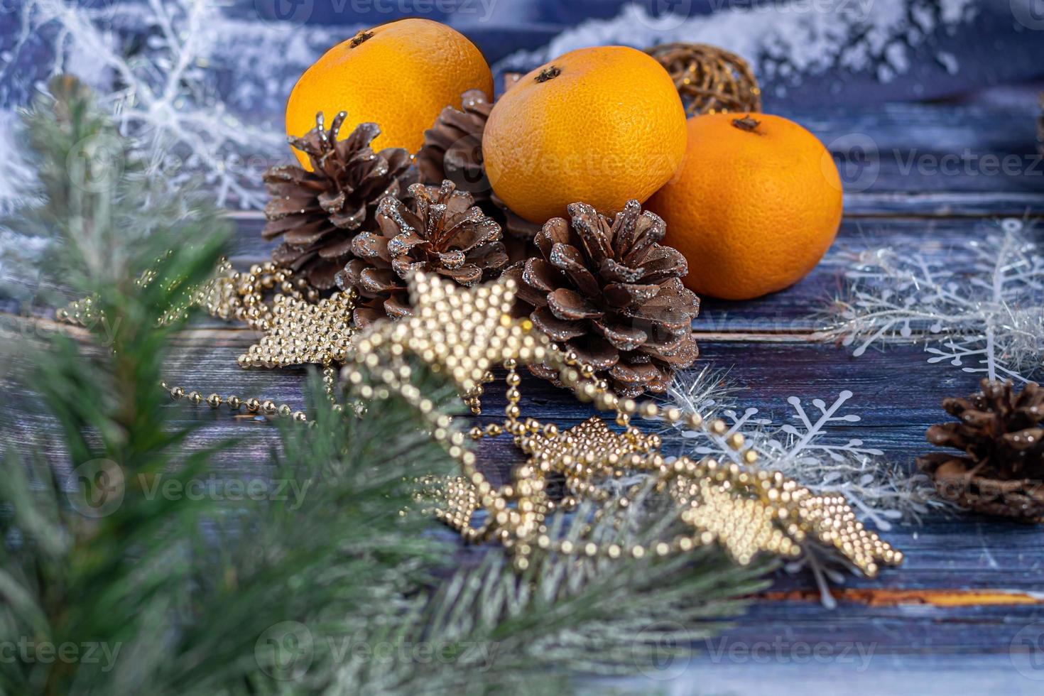 mandarinas sobre un fondo gris con ramas de un árbol de navidad, al fondo una ventana con nieve. concepto de año nuevo. foto