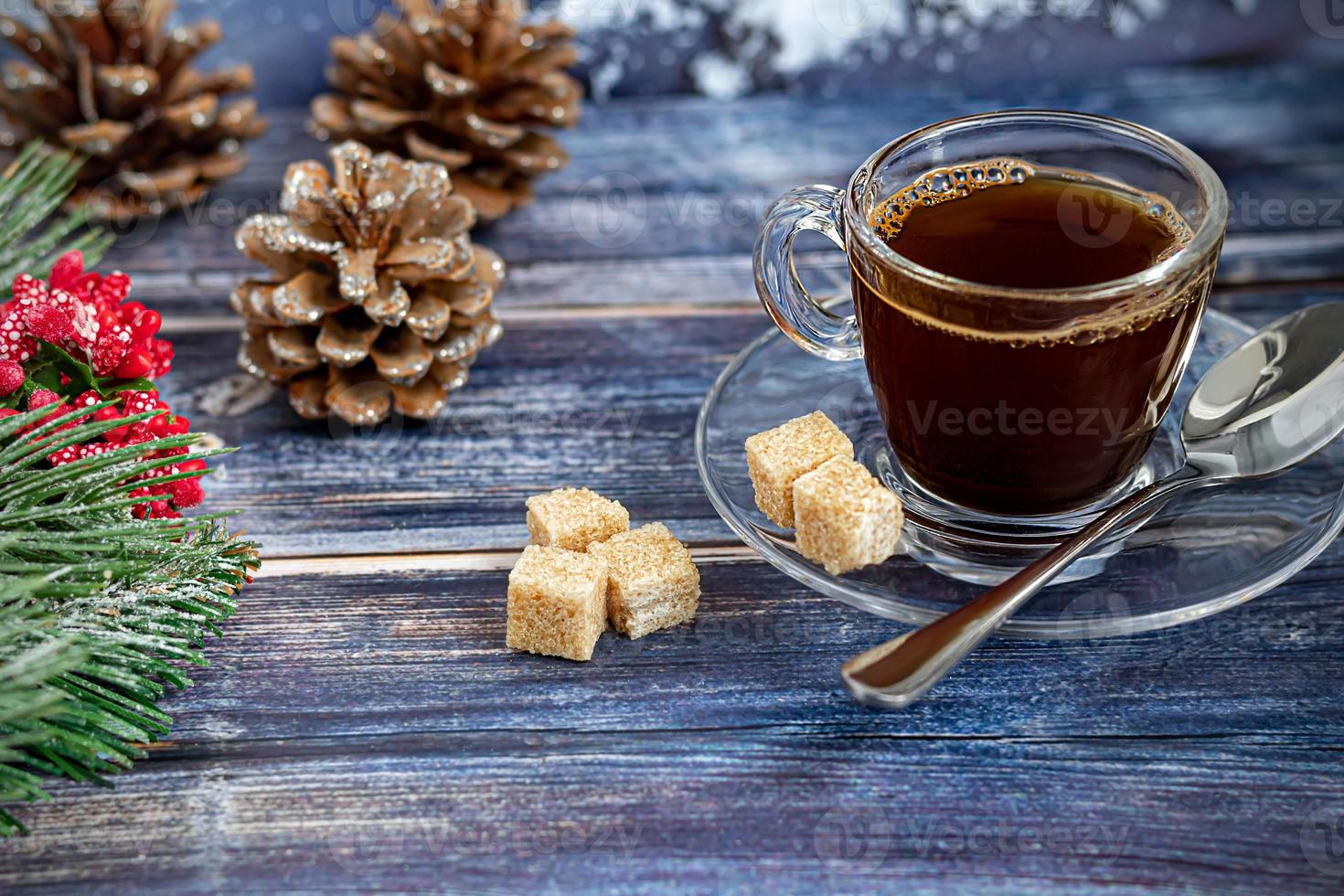 A cup of aromatic coffee with brown sugar, Christmas decorations, branches of a Christmas tree. Holiday concept New Year. On a wooden background. photo