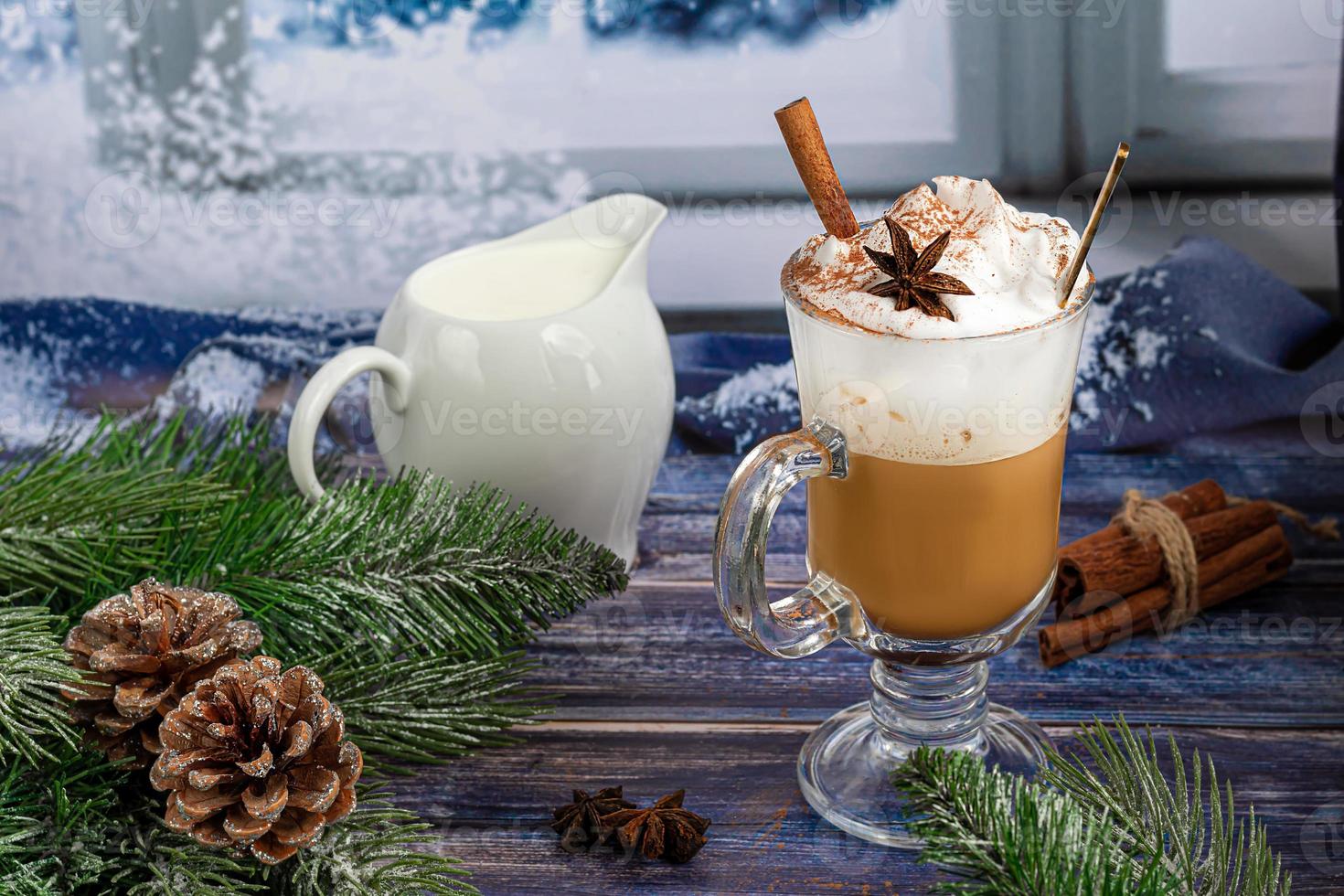 Hot coffee latte with cinnamon sticks, sprinkled with cinnamon. Christmas decorations, branches of a Christmas tree. Holiday concept New Year. photo