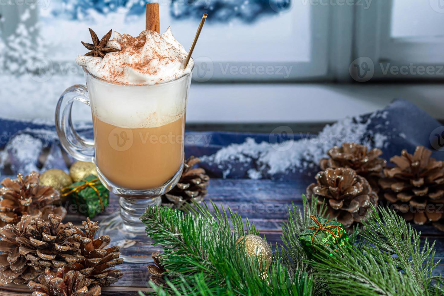Hot coffee latte with cinnamon sticks, sprinkled with cinnamon. Christmas decorations, branches of a Christmas tree. Holiday concept New Year. photo