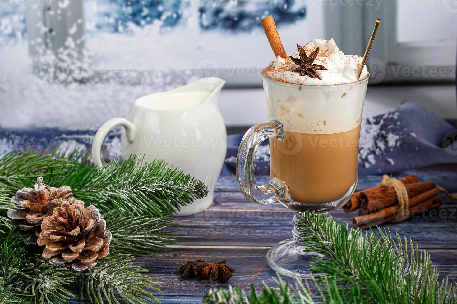 Hot coffee latte with cinnamon sticks, sprinkled with cinnamon. Christmas decorations, branches of a Christmas tree. Holiday concept New Year. photo