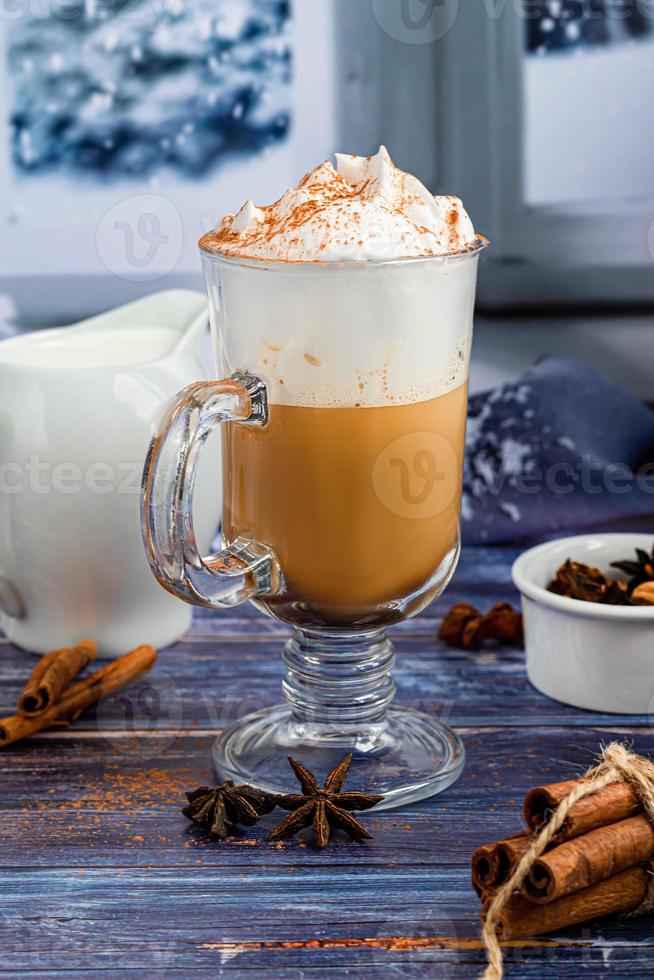 Hot coffee latte with cinnamon sticks, sprinkled with cinnamon. Christmas decorations, branches of a Christmas tree. Holiday concept New Year. photo