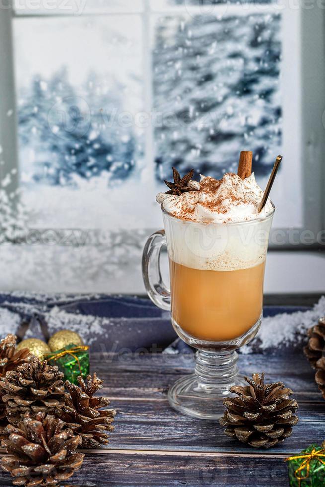 Hot coffee latte with cinnamon sticks, sprinkled with cinnamon. Christmas decorations, branches of a Christmas tree. Holiday concept New Year. photo