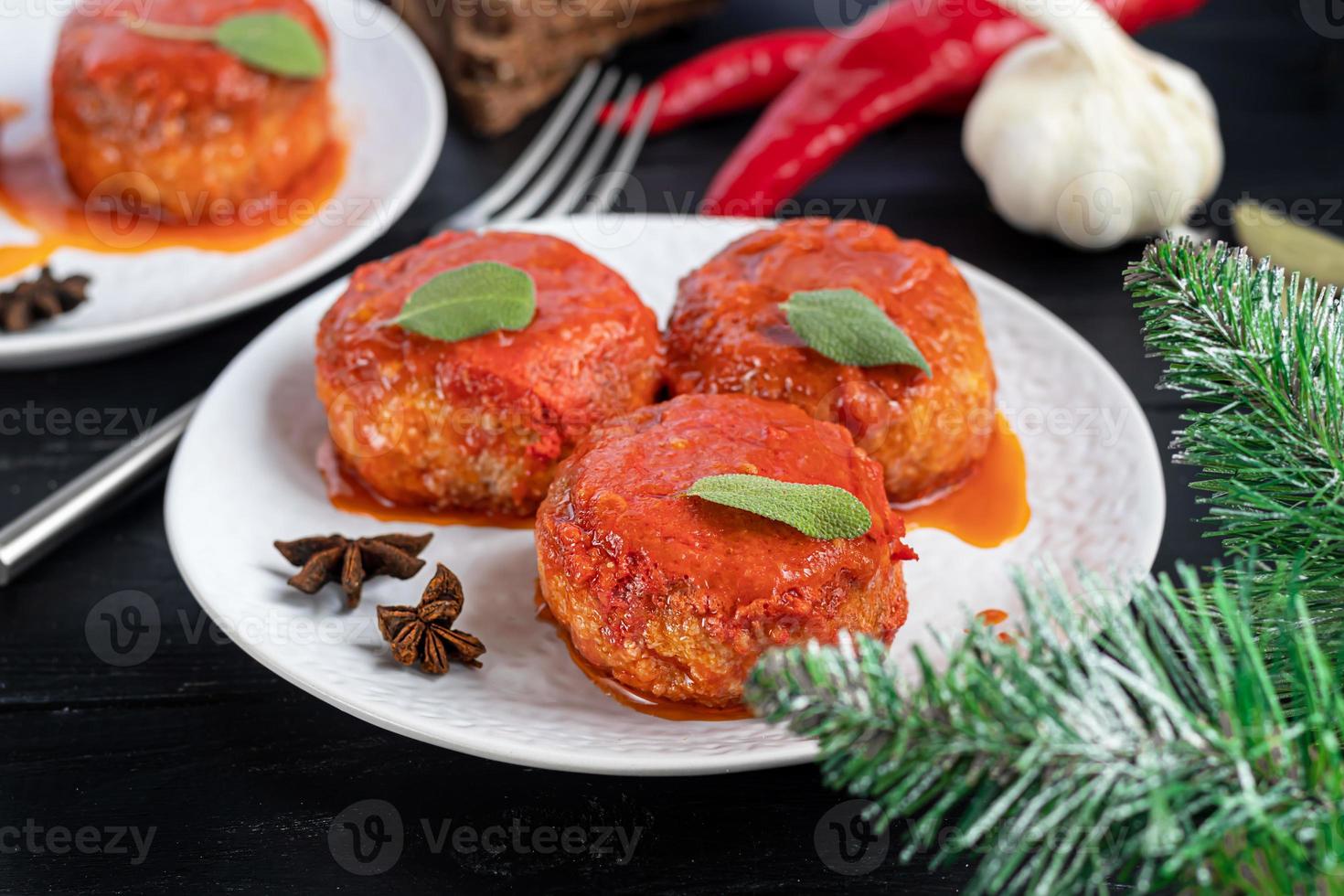 Fish cakes in tomato juice with onions and carrots. Diet. Sauerkraut. On a dark wooden background. photo