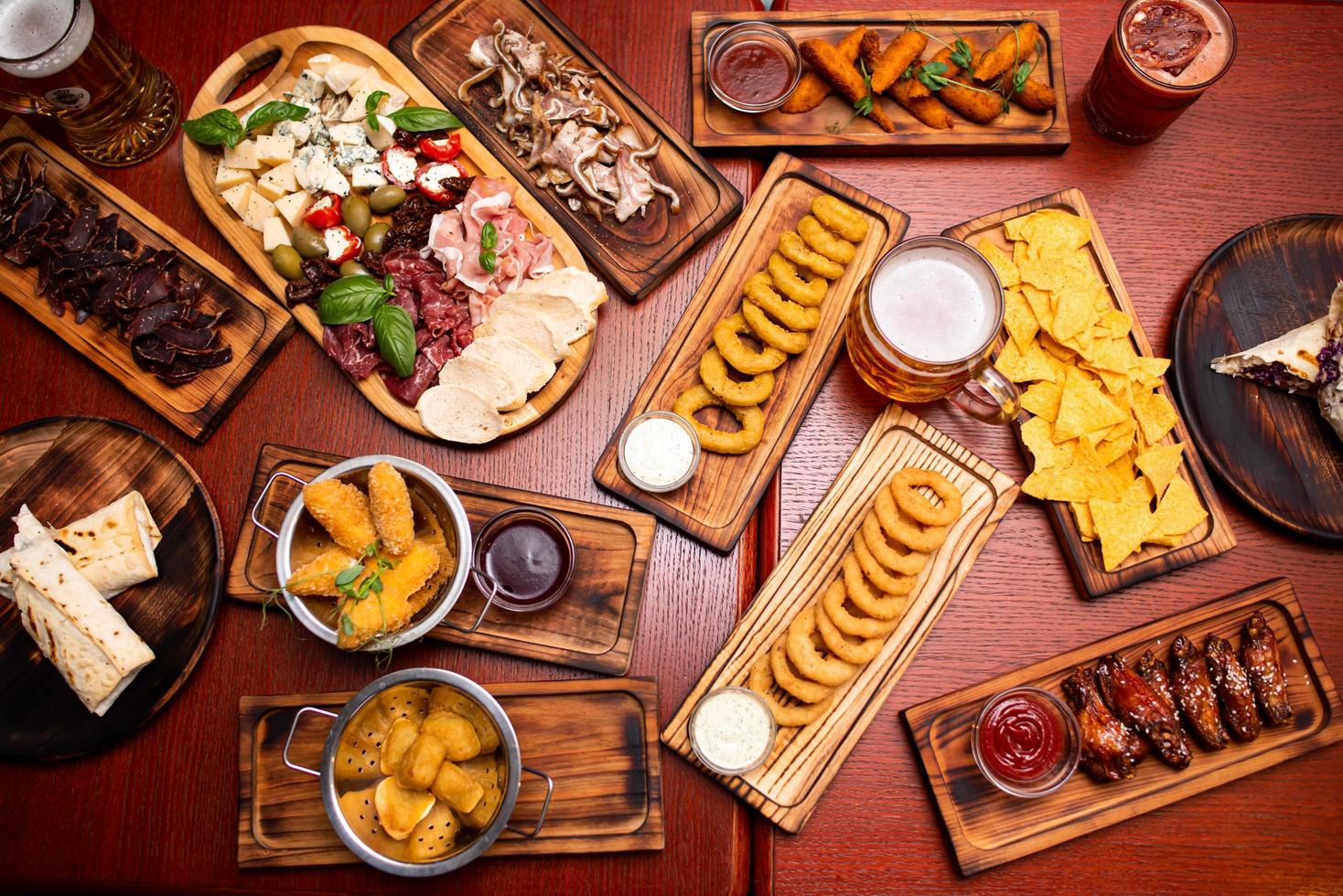 Assorted beer snacks, fast food. Fried Cheese Sticks, cured meats, nuggets with mug of beer. photo