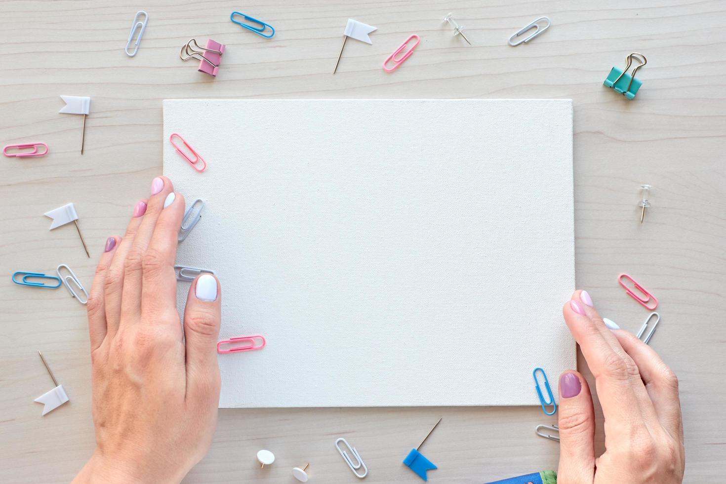 School office supplies on wooden background. Back to school concept. White board with hands for copy space. Top view ready for your design photo