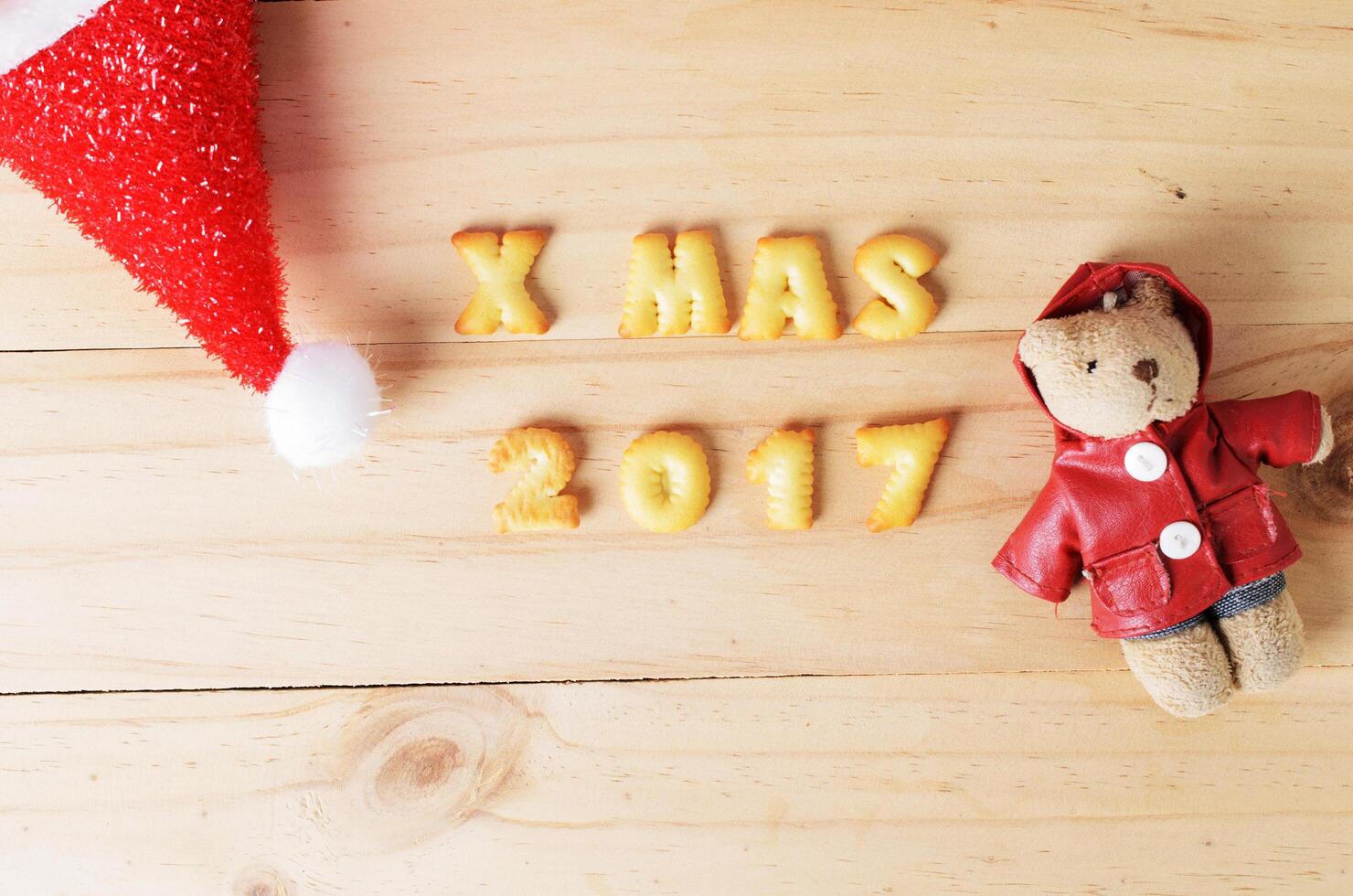 sombrero de navidad y decoración de oso sobre fondos de madera arriba foto