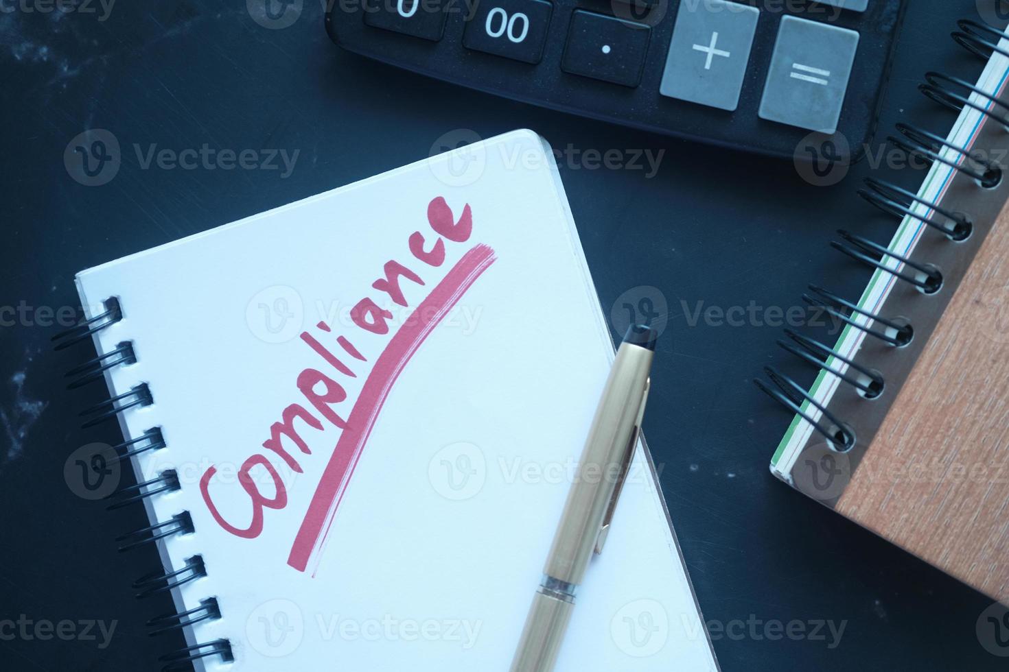 close up of hand written Compliance text on notepad photo