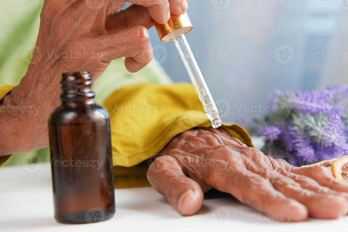 mujeres mayores aplicando aceites esenciales en la mano foto