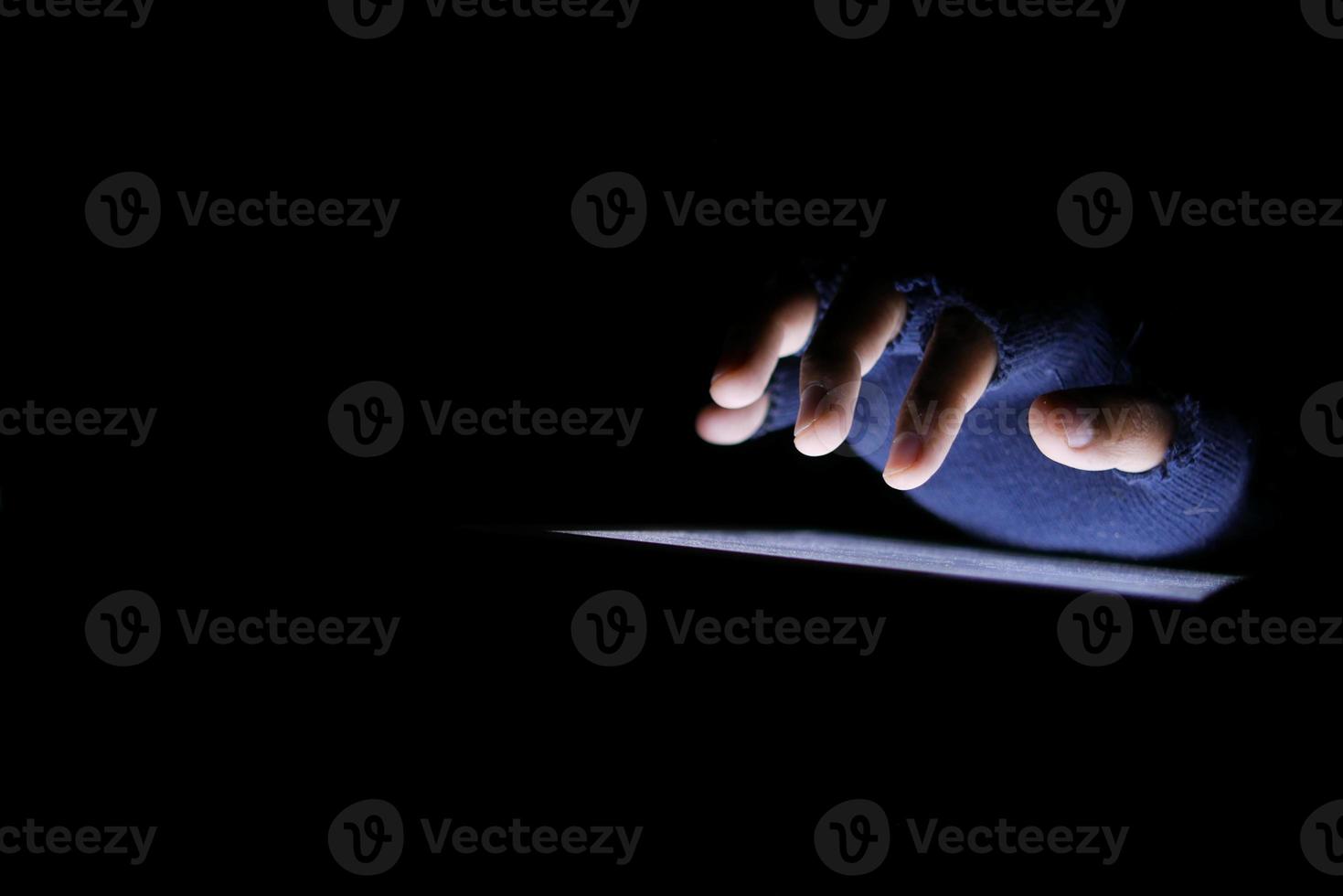 Close up of hacker hand stealing data from digital tablet photo