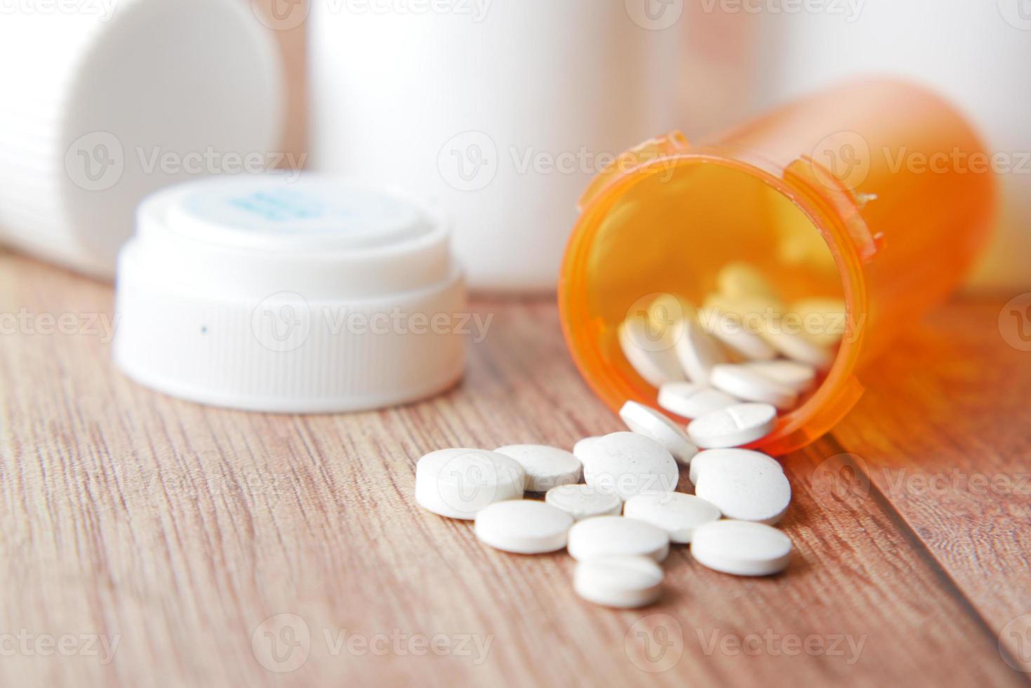 white color medical pills spilling on pink photo